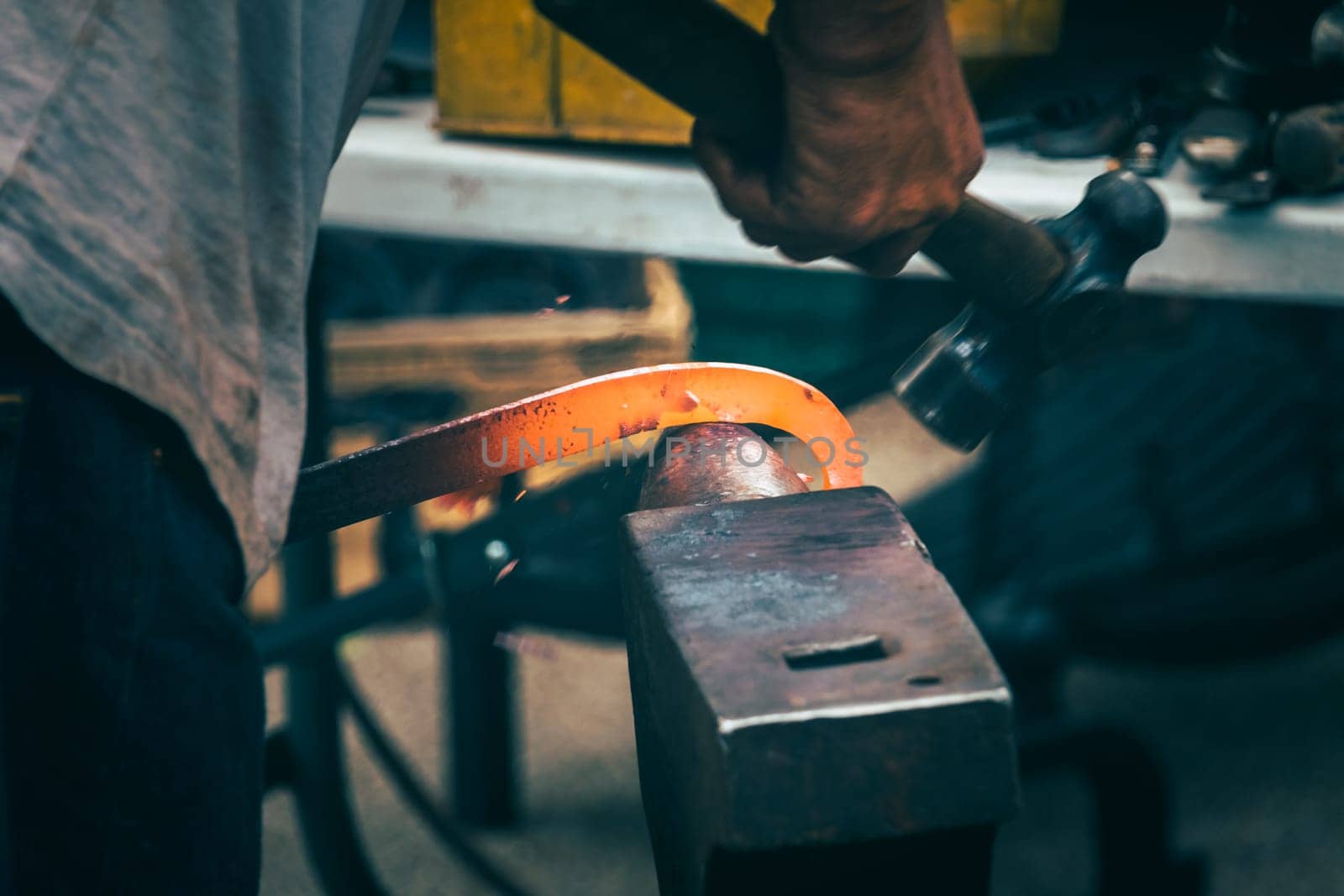 A blacksmith hammering hot iron during medieval fair festival in Streatham Park in London