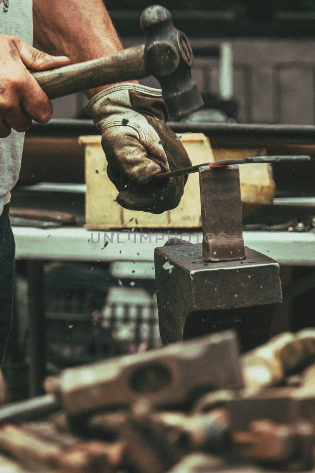 A blacksmith hammering hot iron during medieval fair festival in Streatham Park in London
