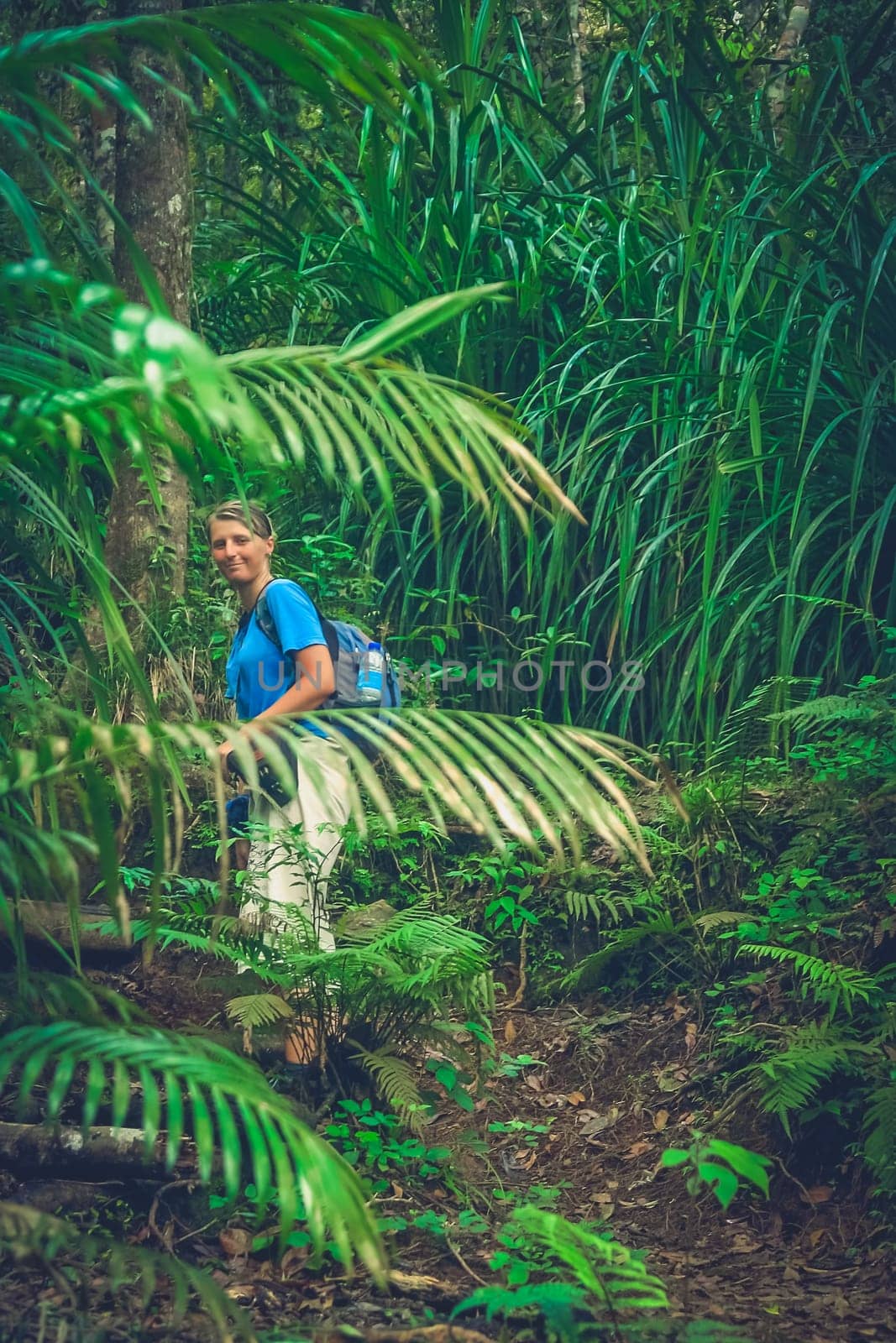 Girl walking up the jungle path to the summit of Gunung Rinjani volcano in Lombok, Indonesia