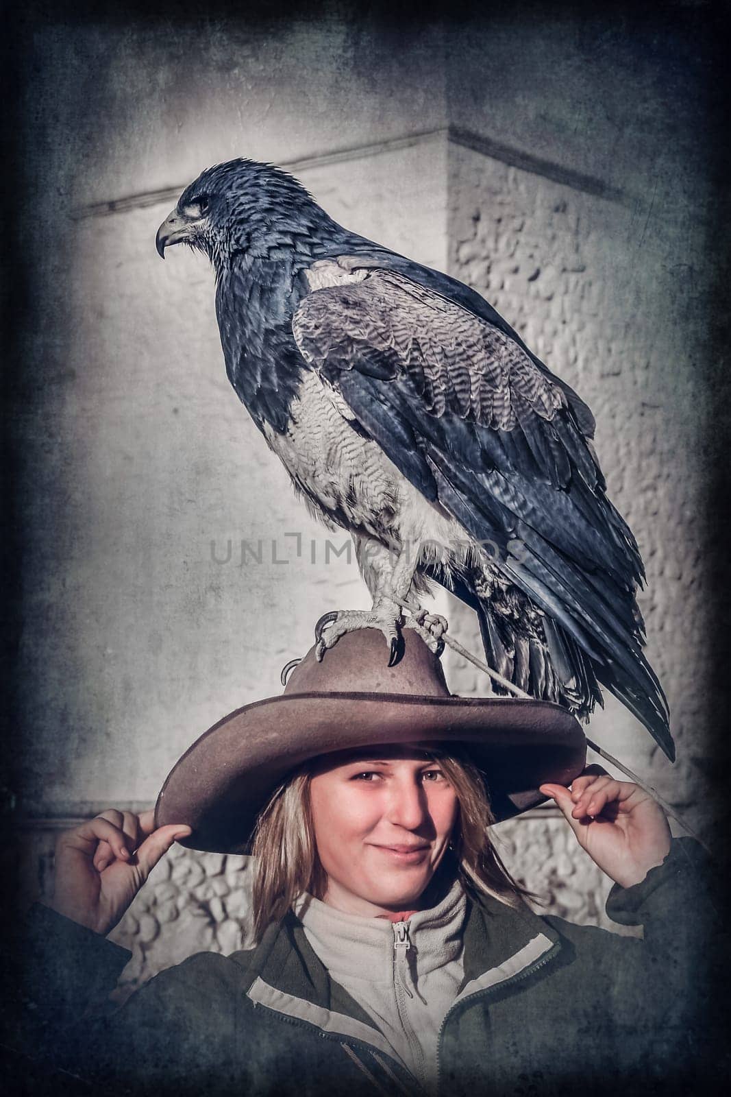 Female tourists with a native to the Andes eagle sitting calmly on her hat in the Colca Canyon in Peru, South America