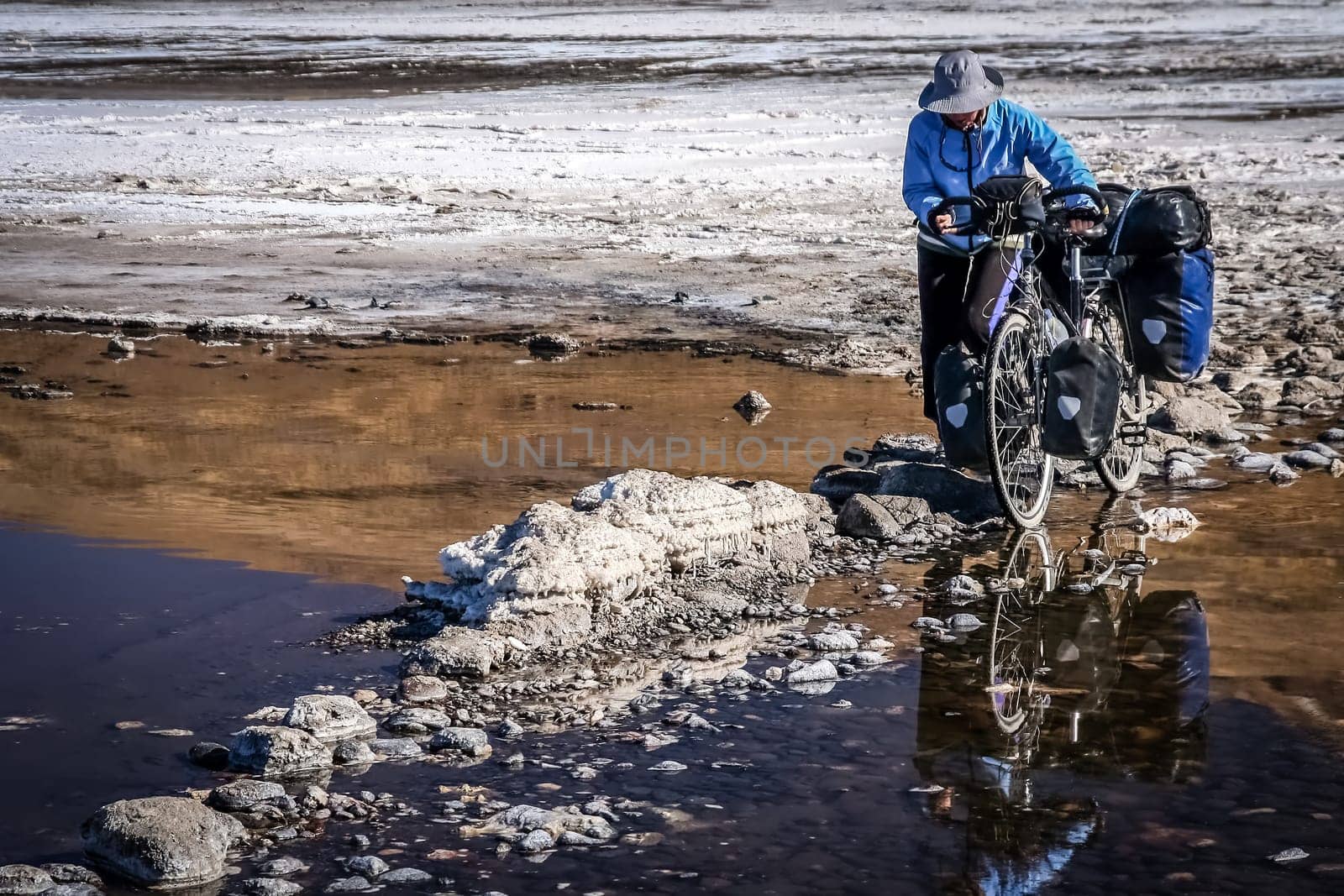 Lonely female cyclist travelling through the biggest salar in the world, Salar de Uyuni in Bolivia