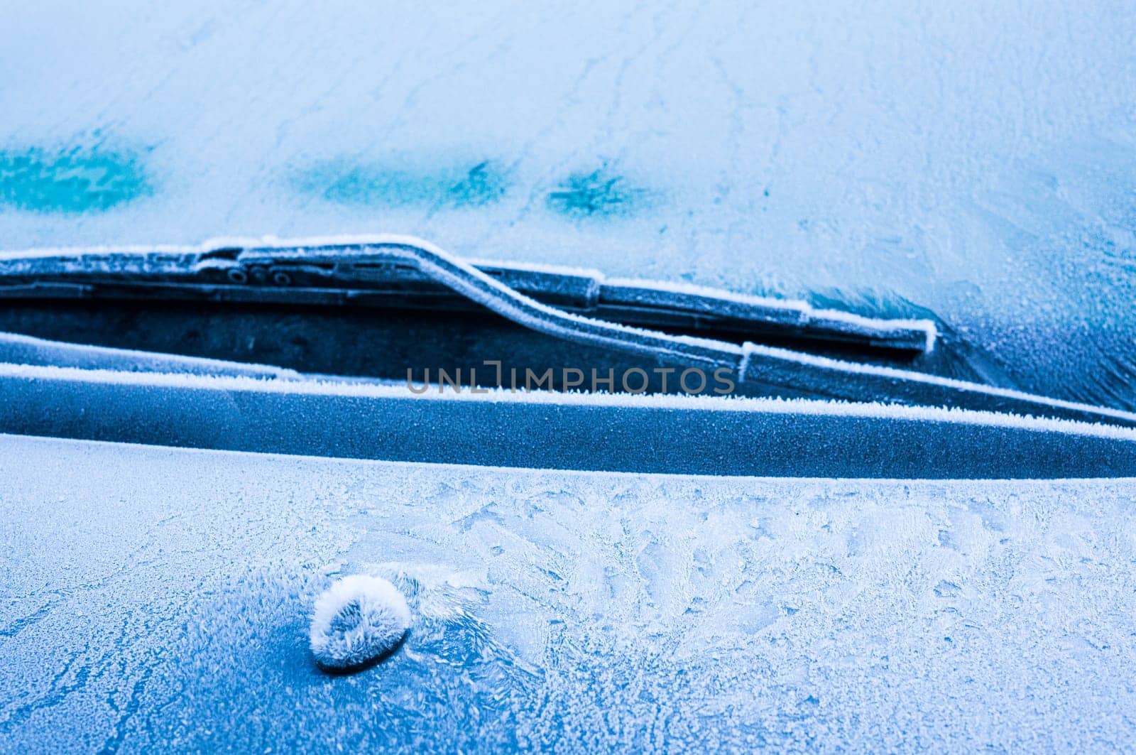 Iceflowers, frozen.The ice-cold frost forms ice crystals in beautiful unique patterns on the window, Hood and wiper on the Car