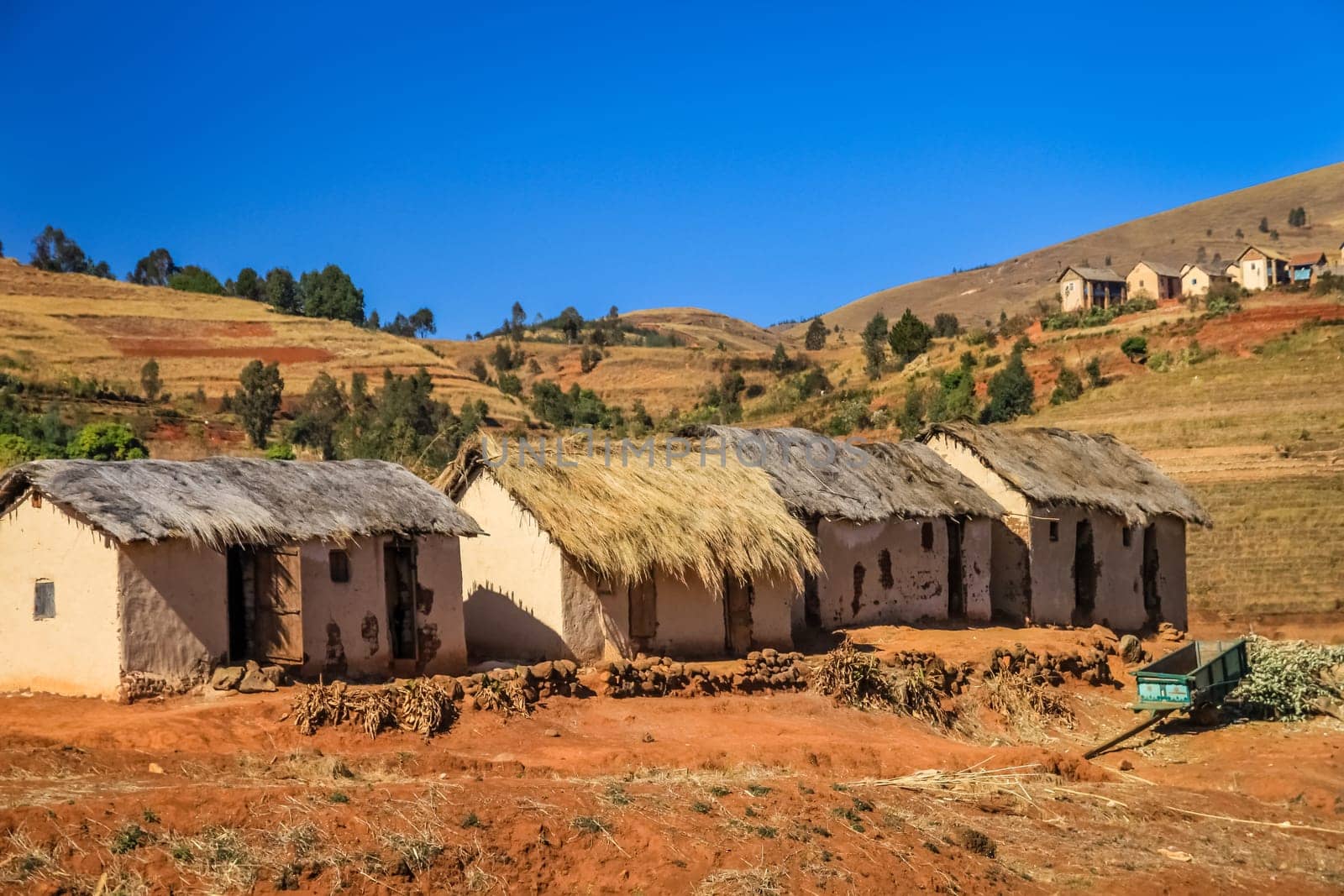 Row of four primitive huts in central plateau in Madagascar