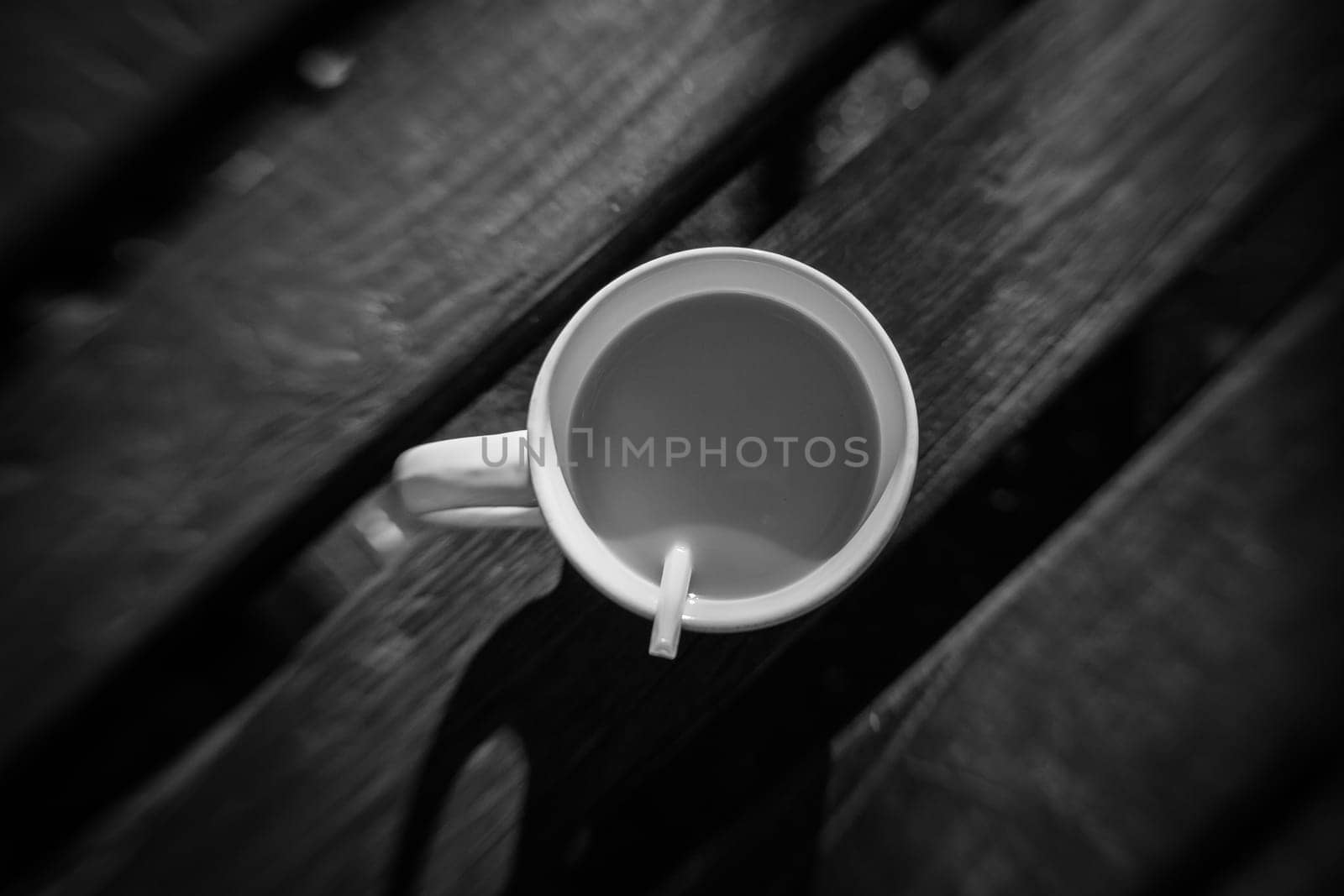 Unfinished coffee on a wooden table in an outdoor cafe