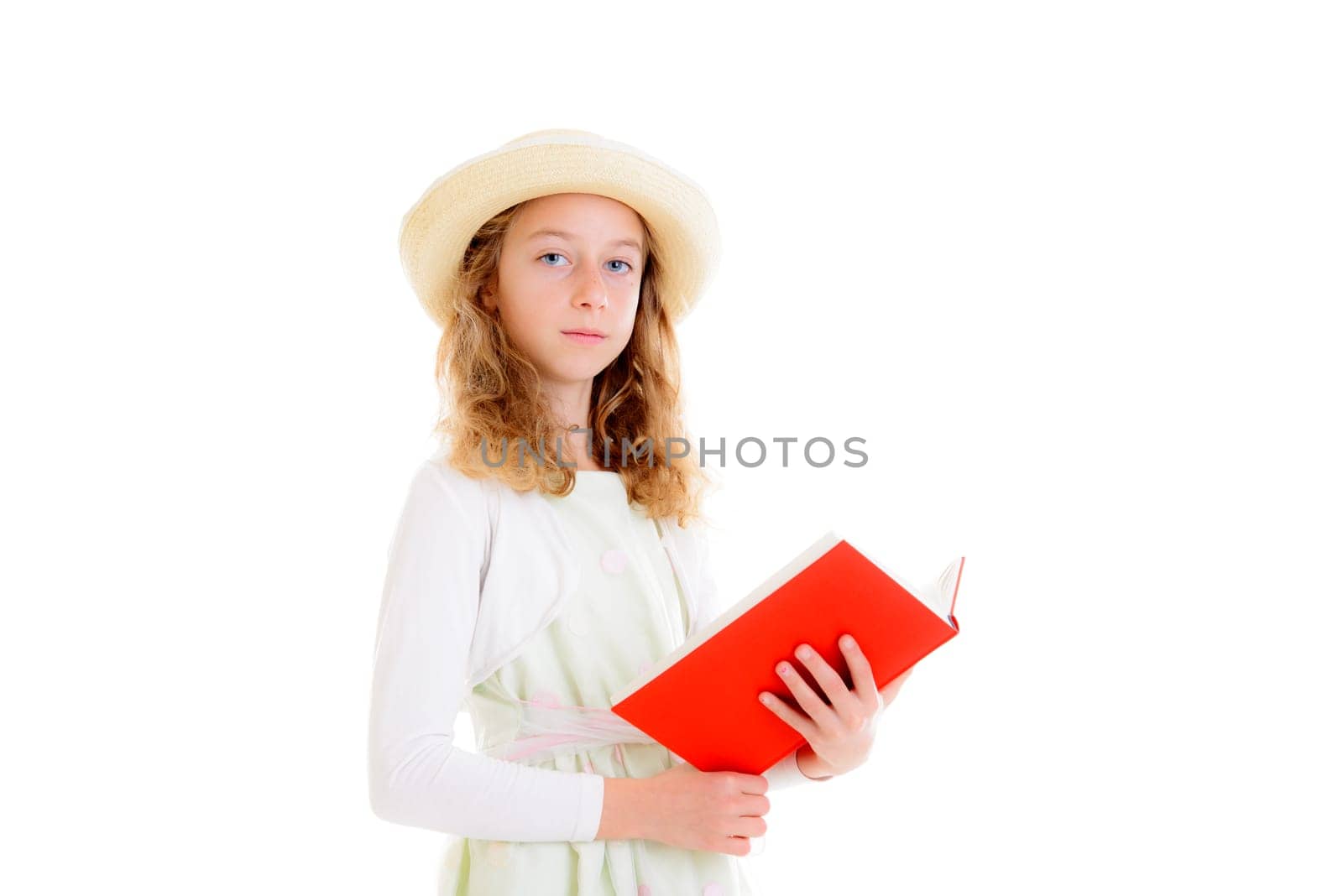 nice girl with blond hair in white dress and straw hat reading red book