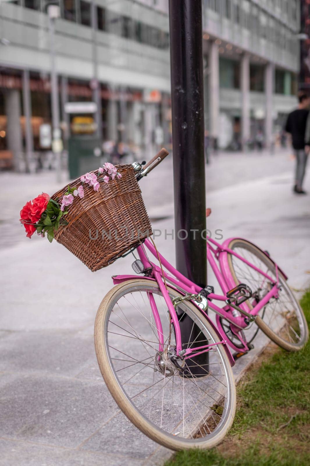 Red and pink bicycle with a basket attached on the street in London centre