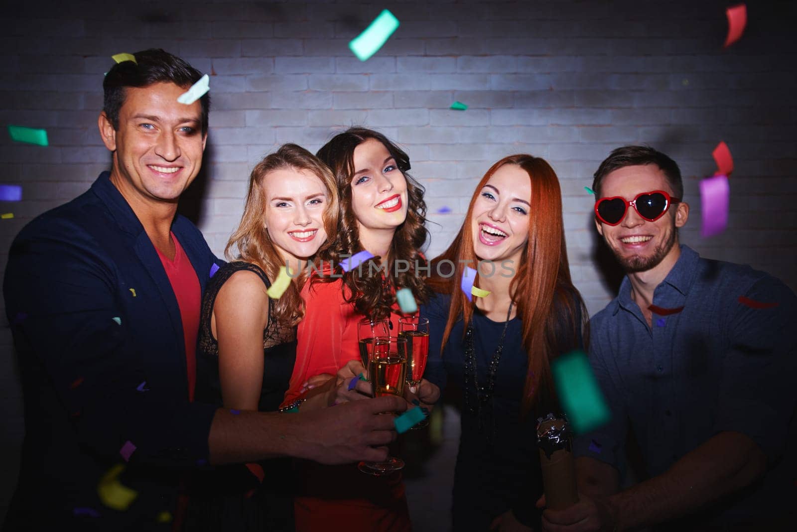 Cheerful friends toasting with champagne at party