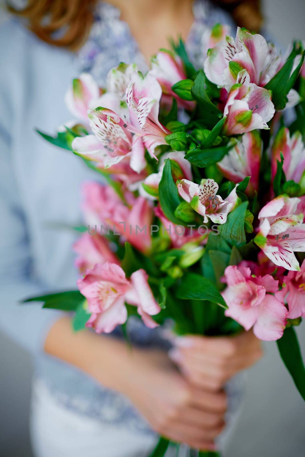 Bunch of fresh pink lilies held by woman