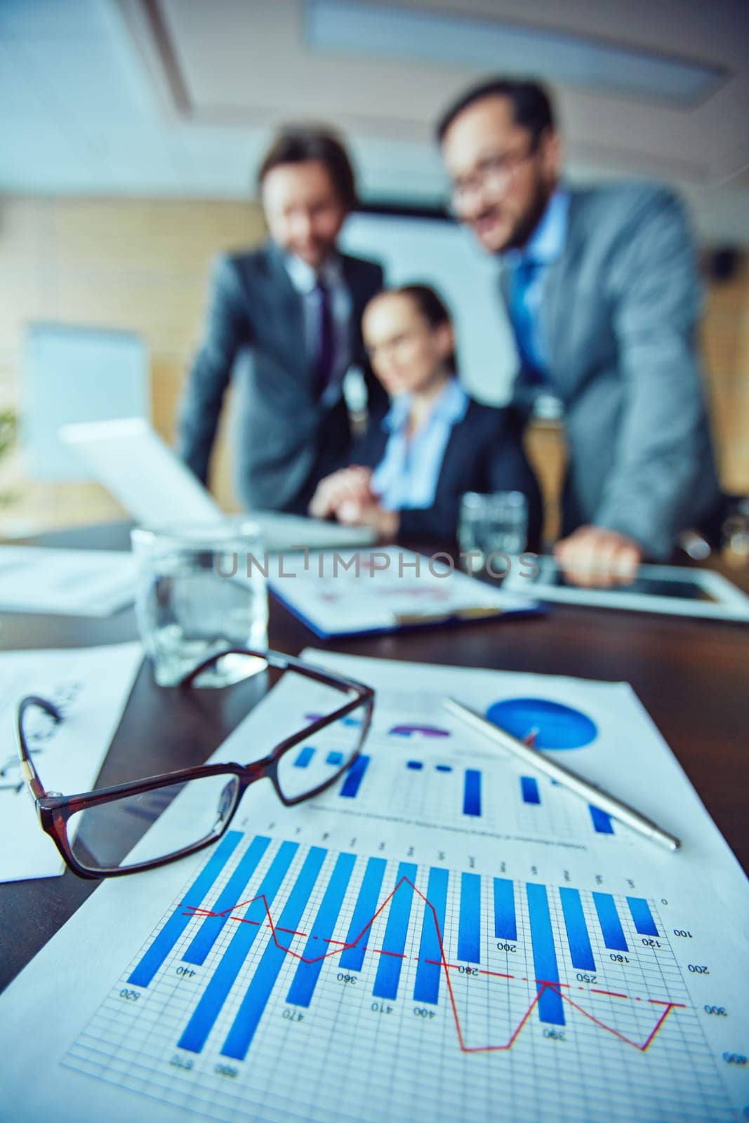 Close-up of document with glasses on table