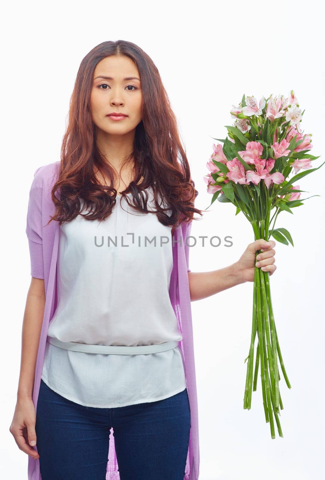 Pretty brunette with bunch of white and pink amaryllises looking at camera