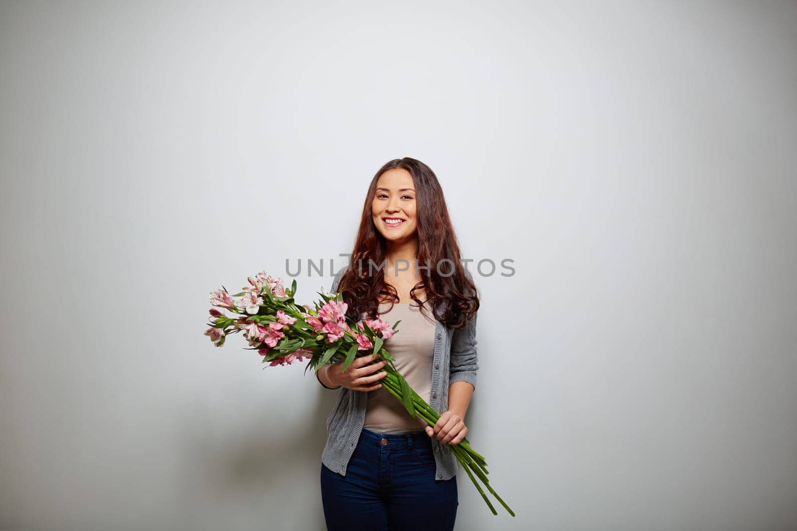 Happy lady with bunch of flowers looking at camera