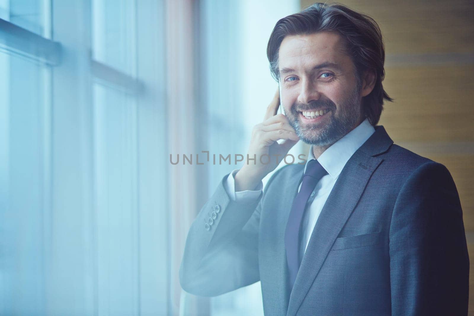 Man with mobile phone smiling and looking at camera