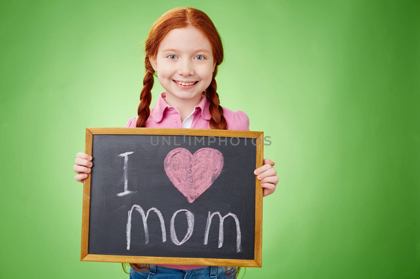 Pretty girl holding board with declaration of love to mother
