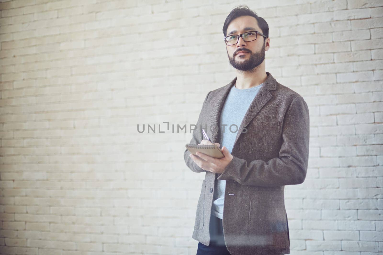 Young businessman making notes in notepad