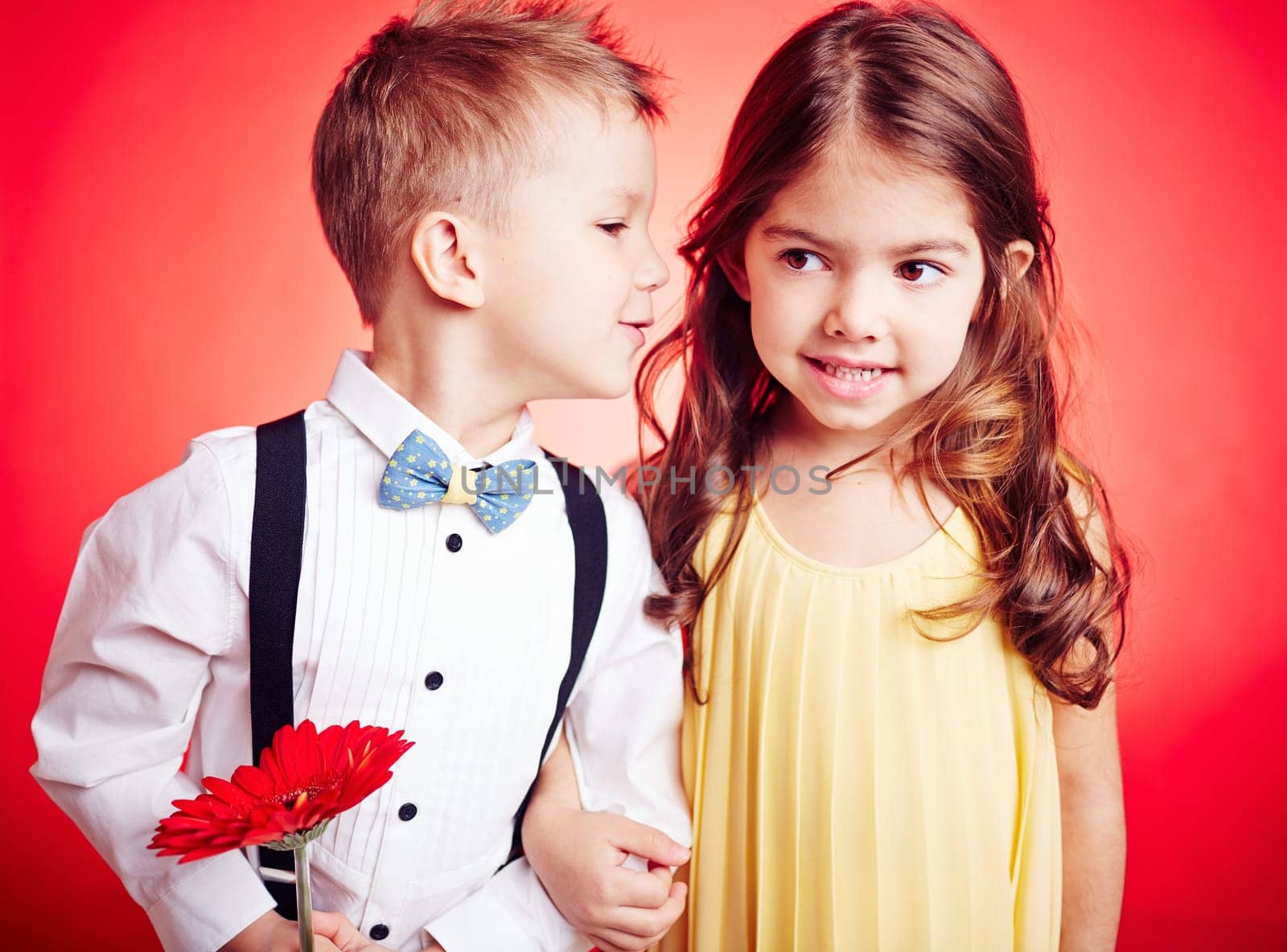Cute little boy whispering something to his girlfriend
