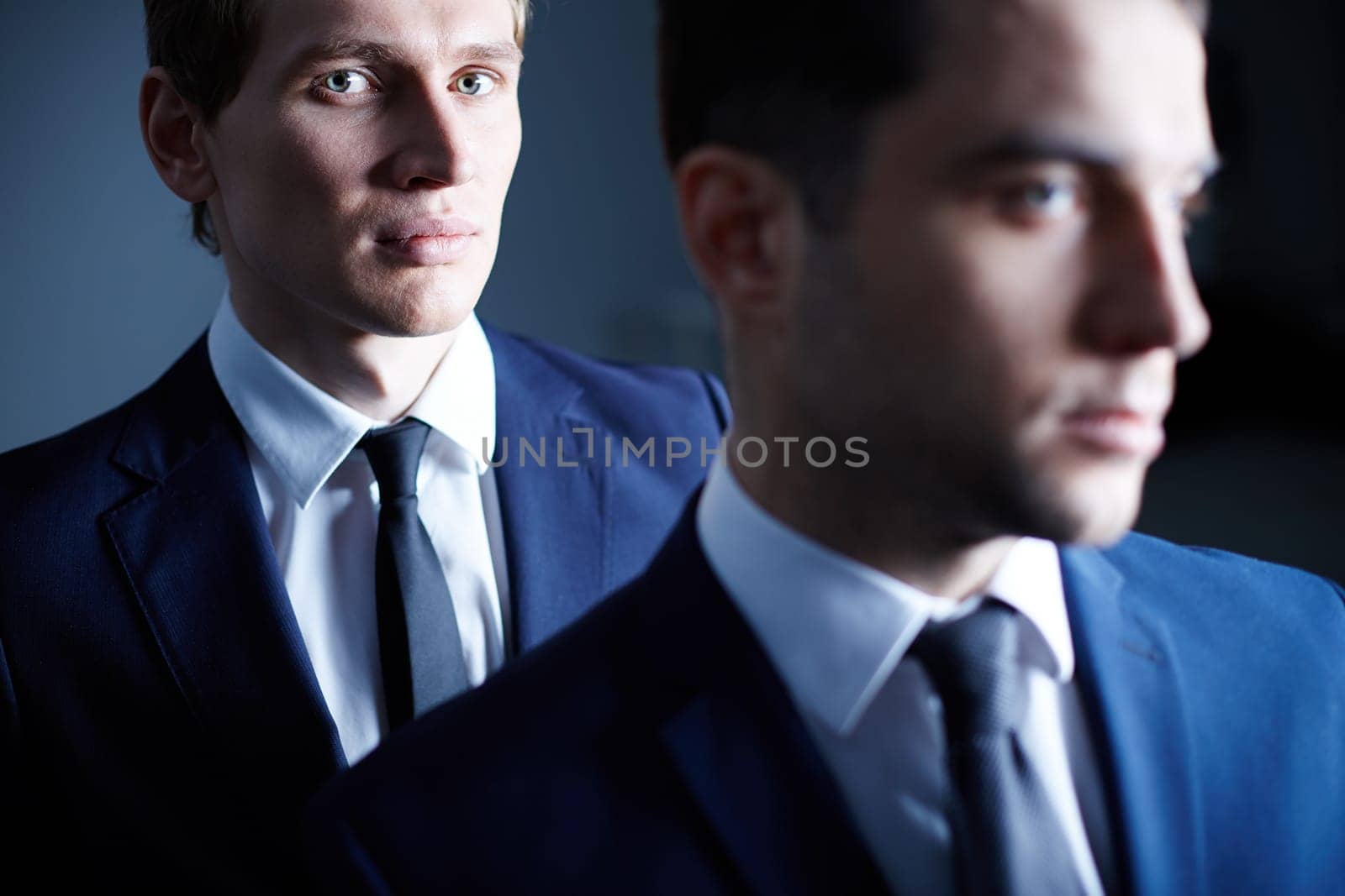 Young businessman standing with other men in the dark