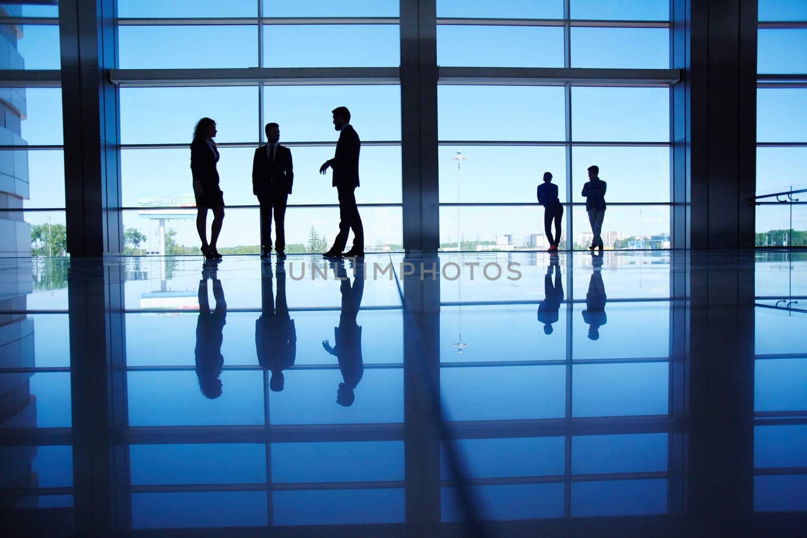 Silhouettes of people communicating in office building