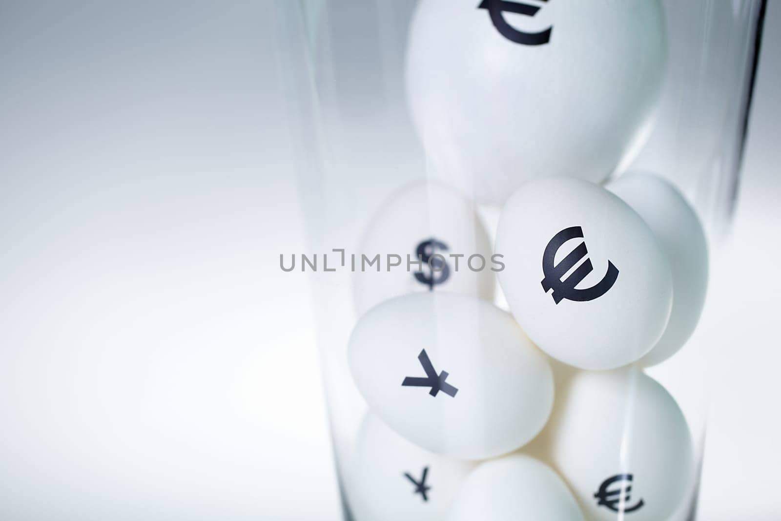 Close-up of eggs with currency signs in glass