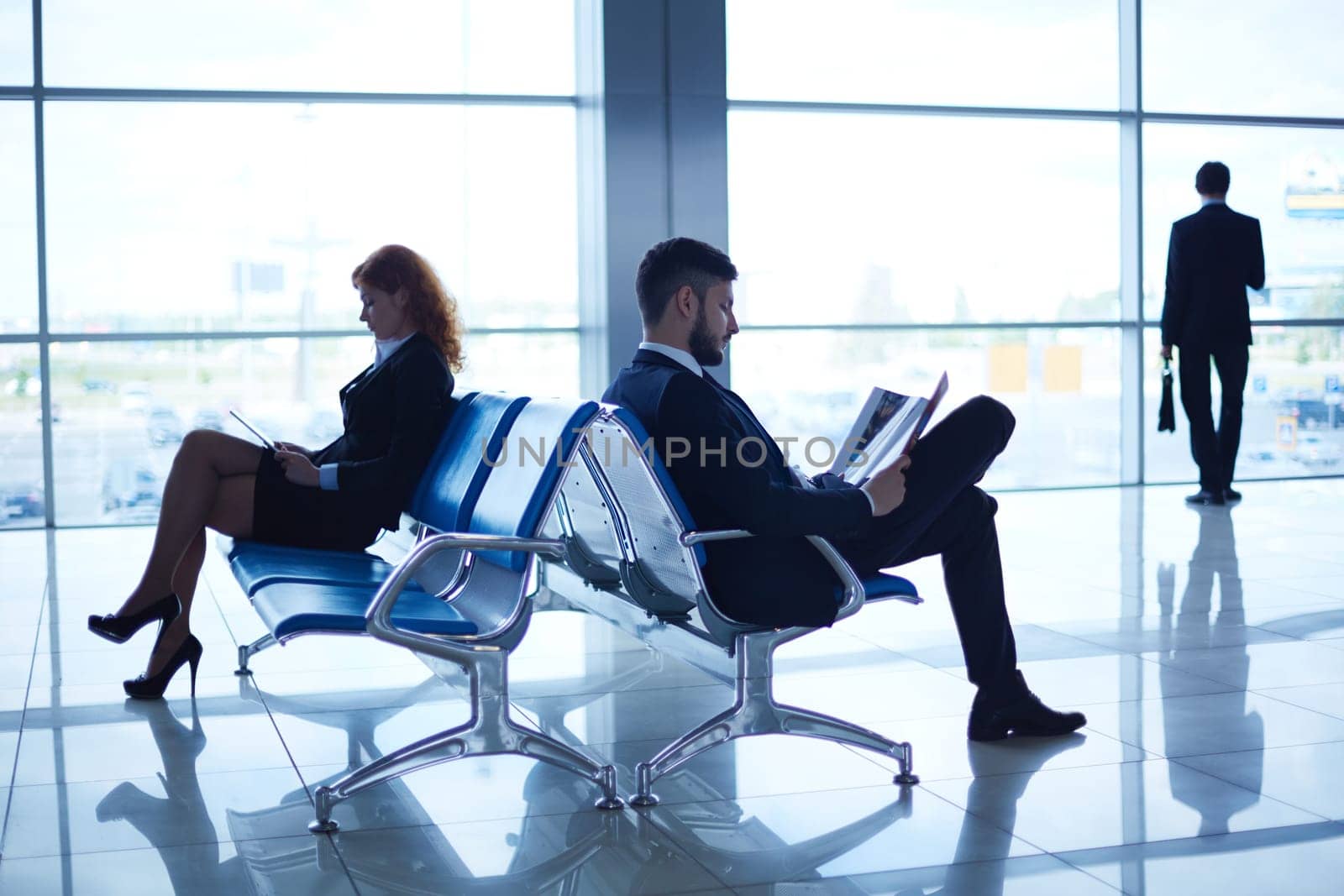 Business people reading periodicals in the airport