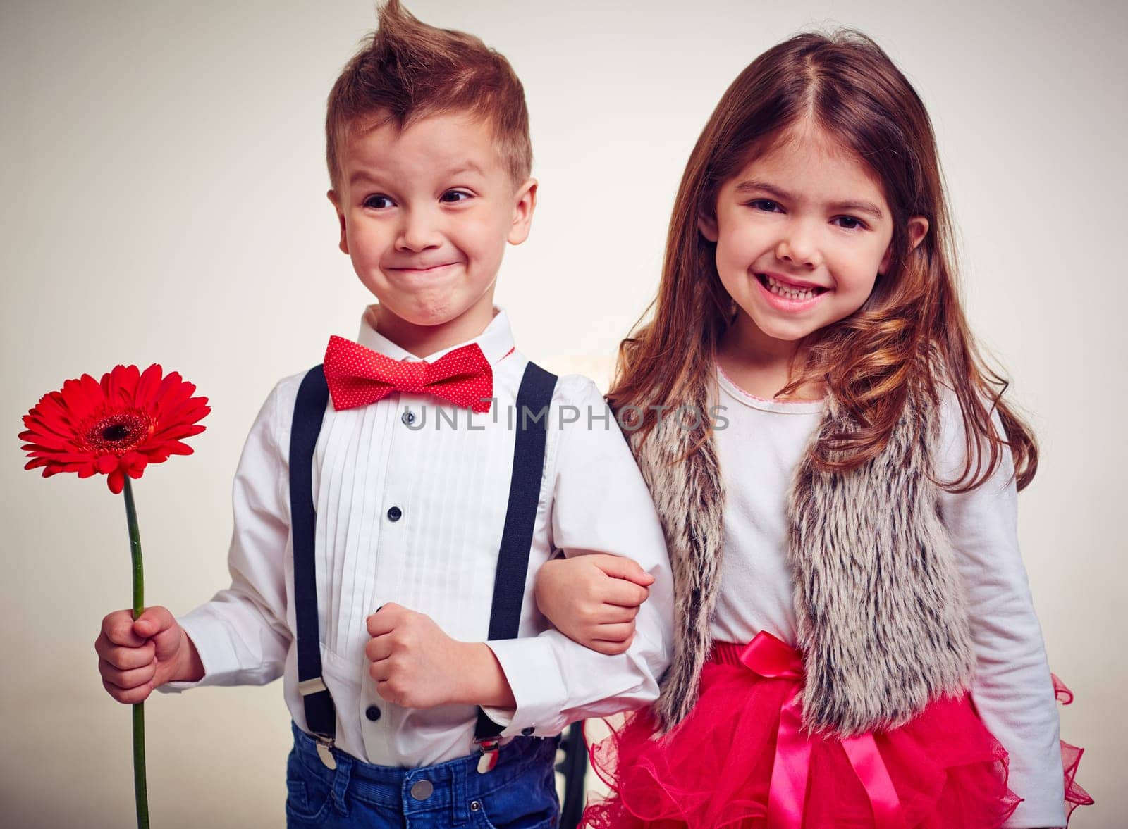 Portrait of well-dressed little kids arm in arm