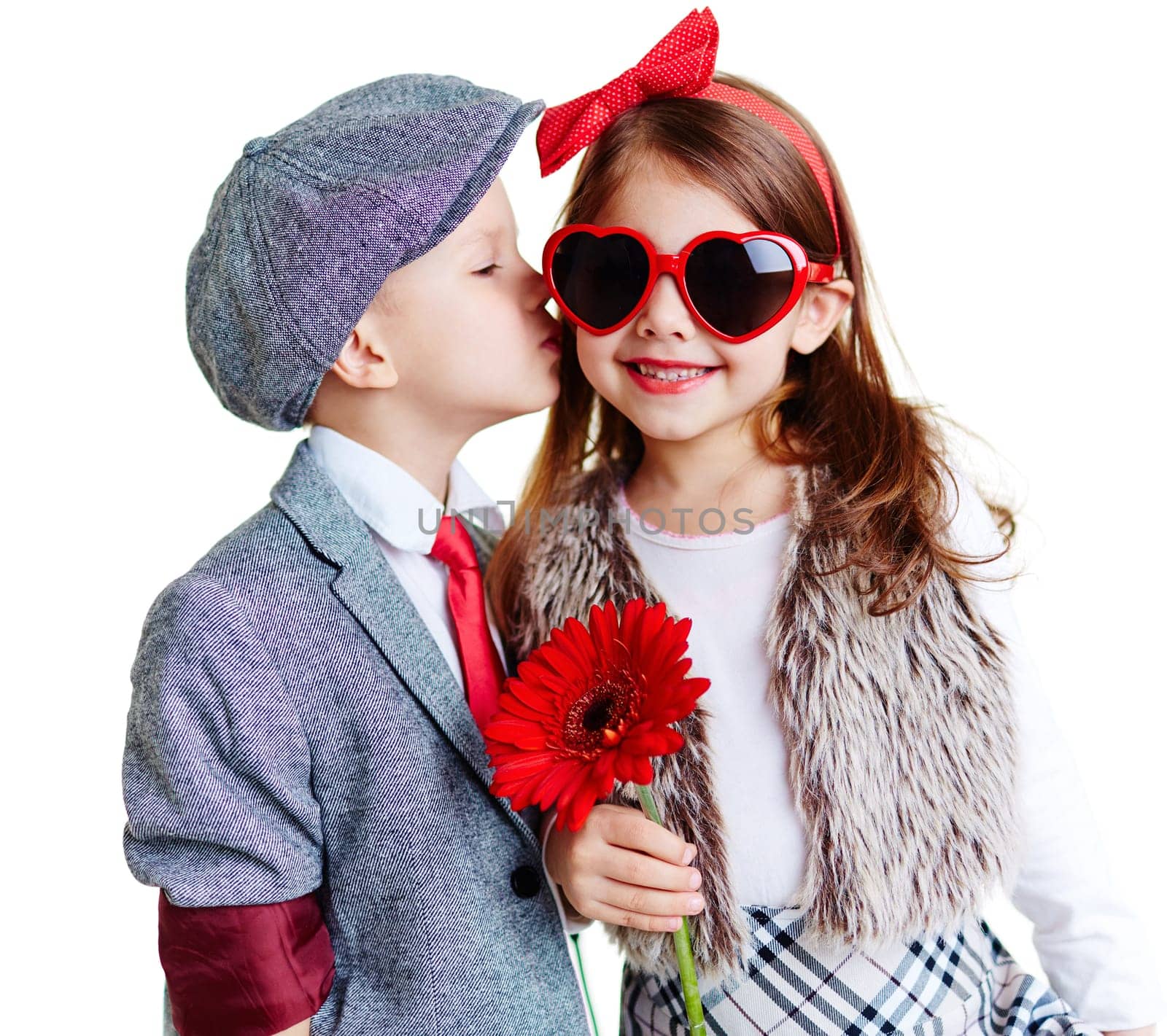 Portrait of well-dressed children, boy kissing a girl