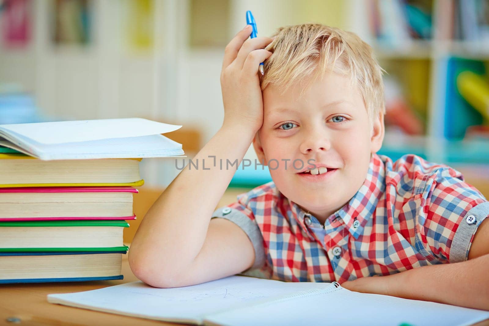 Happy pupil looking at camera by the desk