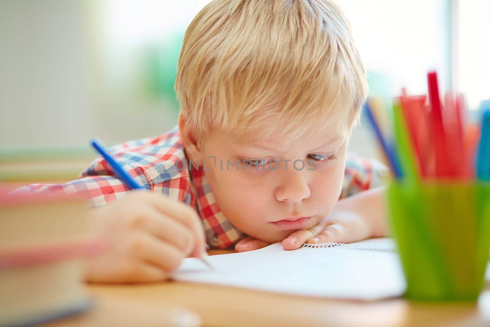 Serious learner making notes or drawing in exercise book