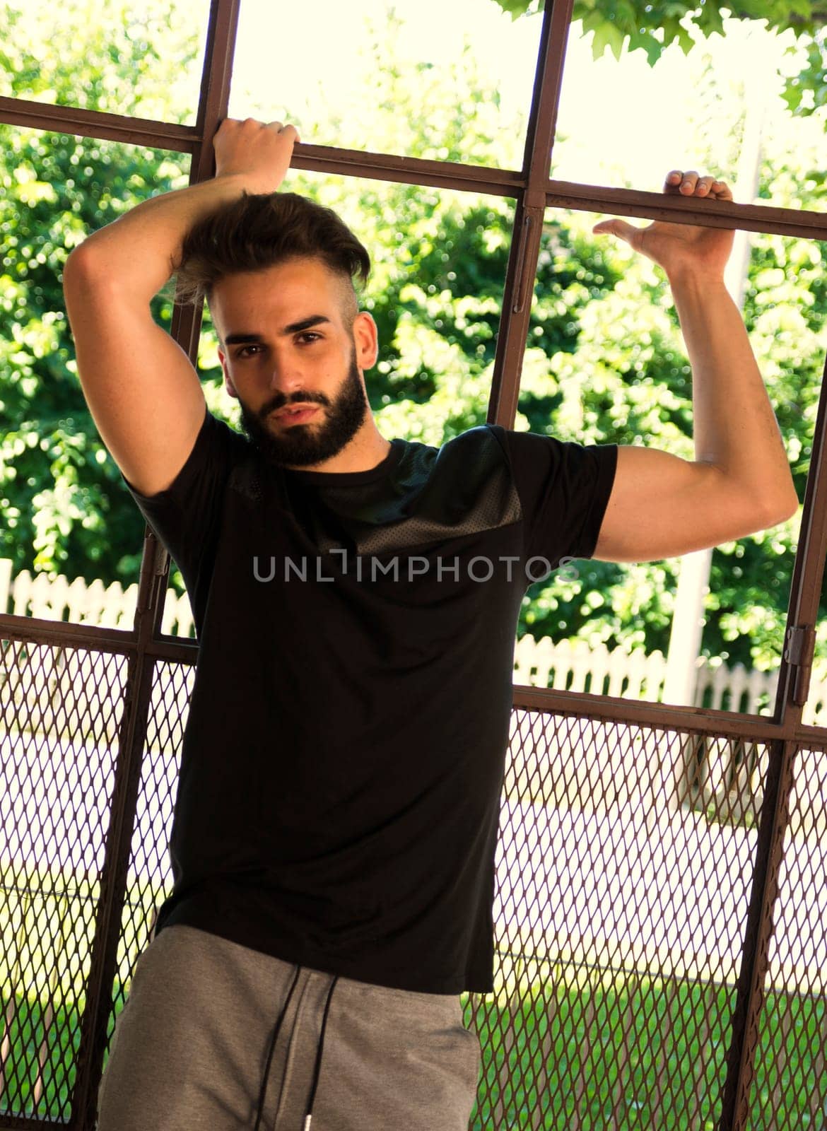 Handsome young man with beard against big metal window frame
