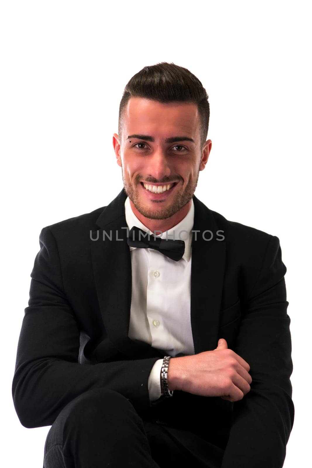 Handsome young man with suit and bowtie isolated on white, looking at camera