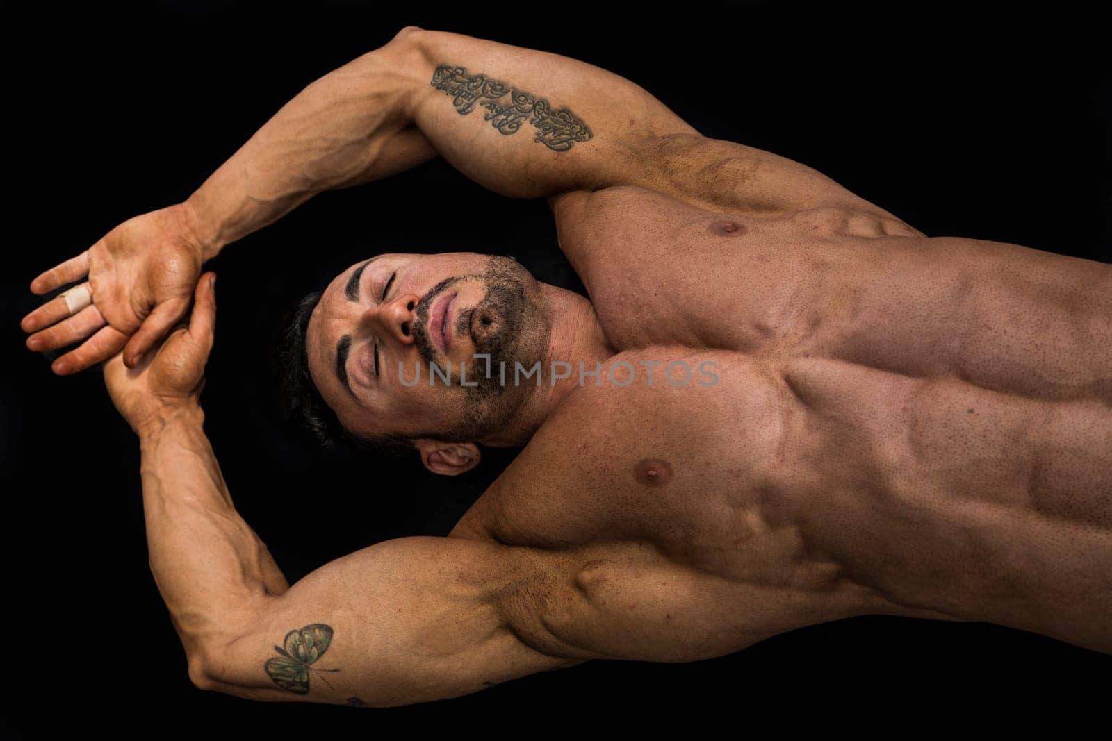 Attractive young muscle man laying on the floor with muscular ripped body