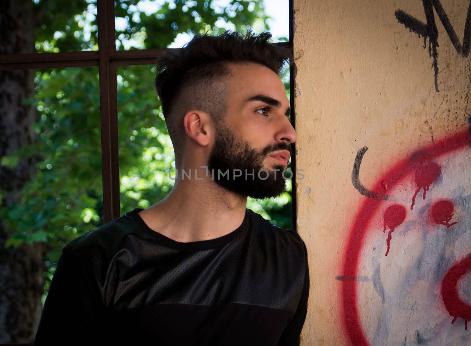 Handsome young man with beard looking to a side