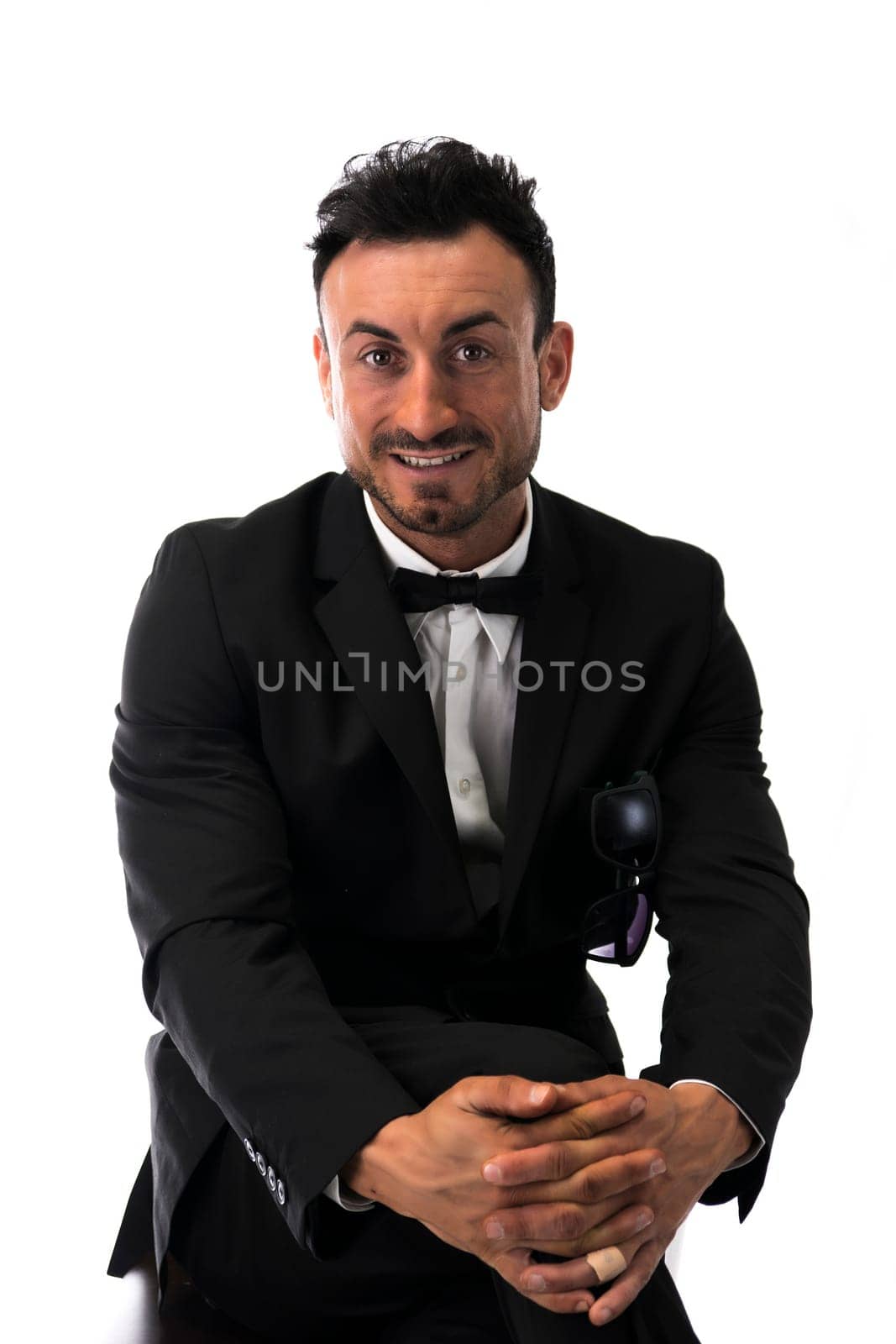 Handsome young man with suit and bowtie isolated on white, looking at camera