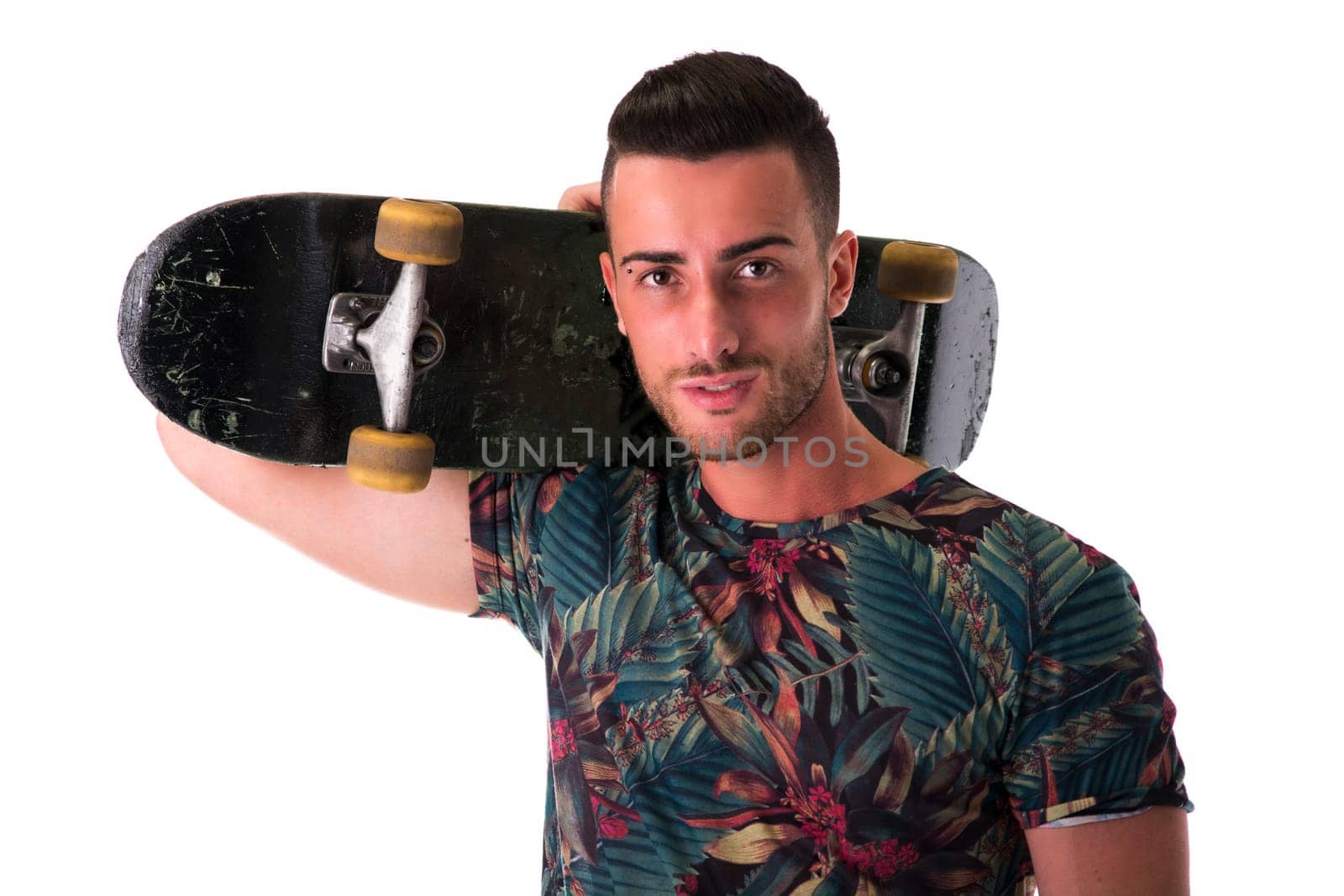 Handsome young man holding skateboard on his shoulder, isolated on white