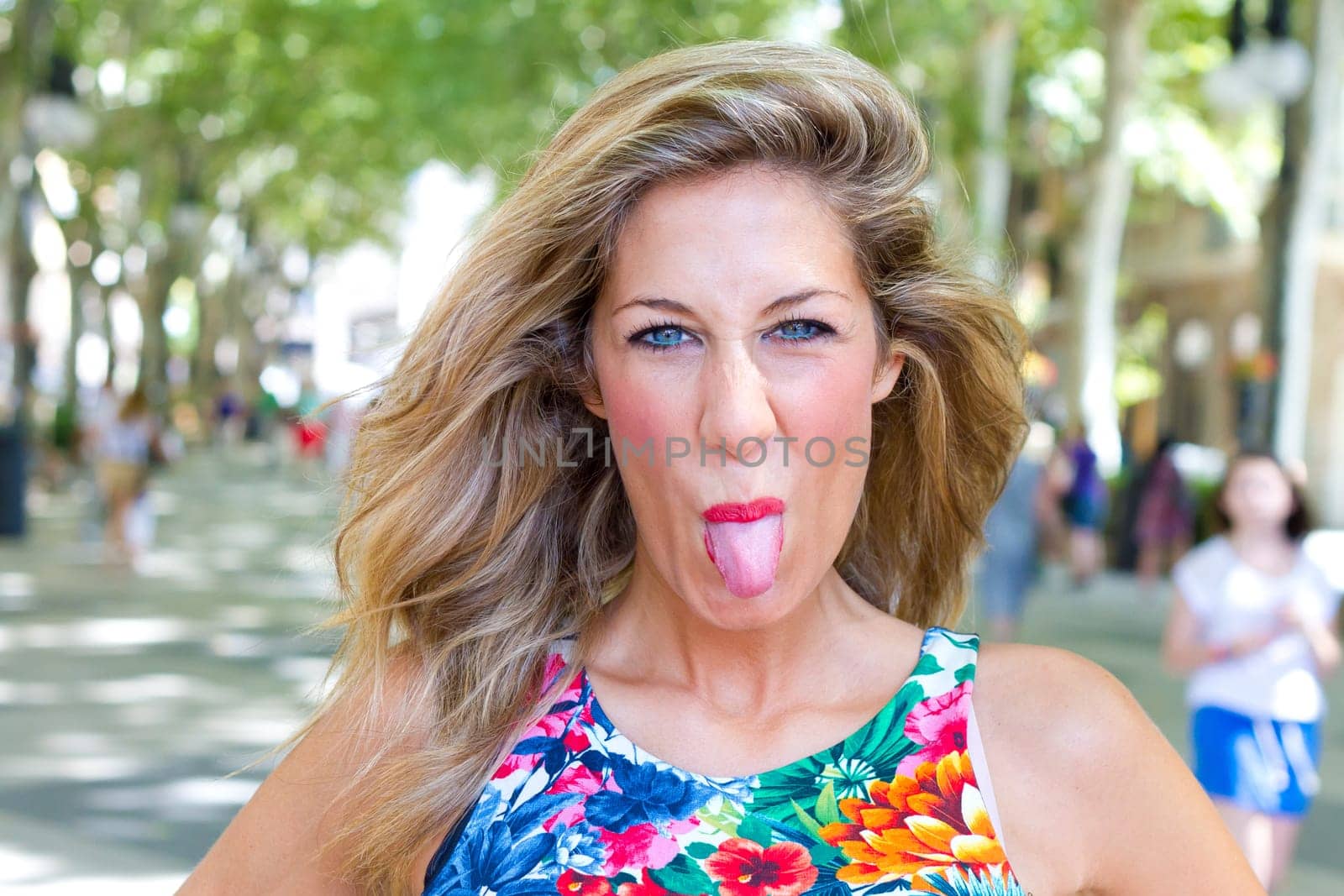Self-confident woman sticks out her tongue