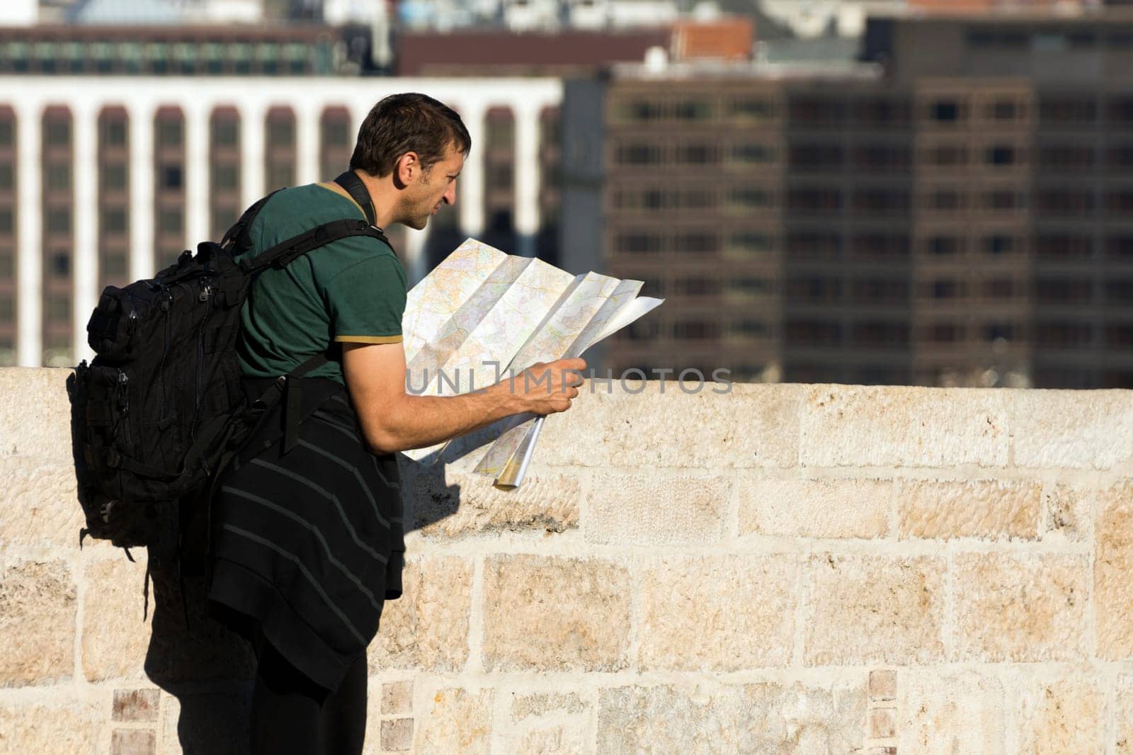 The tourist is looking at the map in the city and looking for his destination.