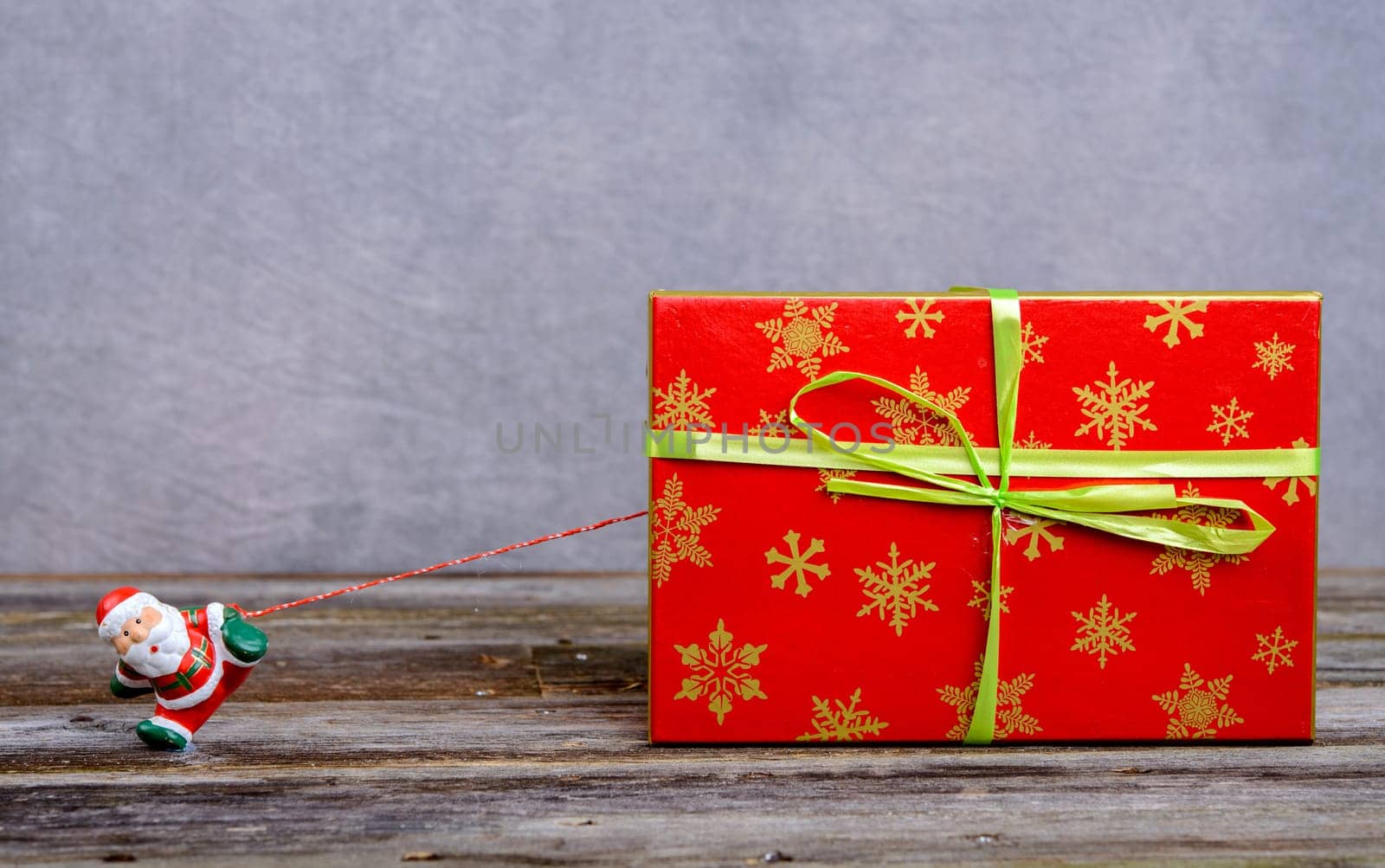 little Santa Claus pulling big red gift box