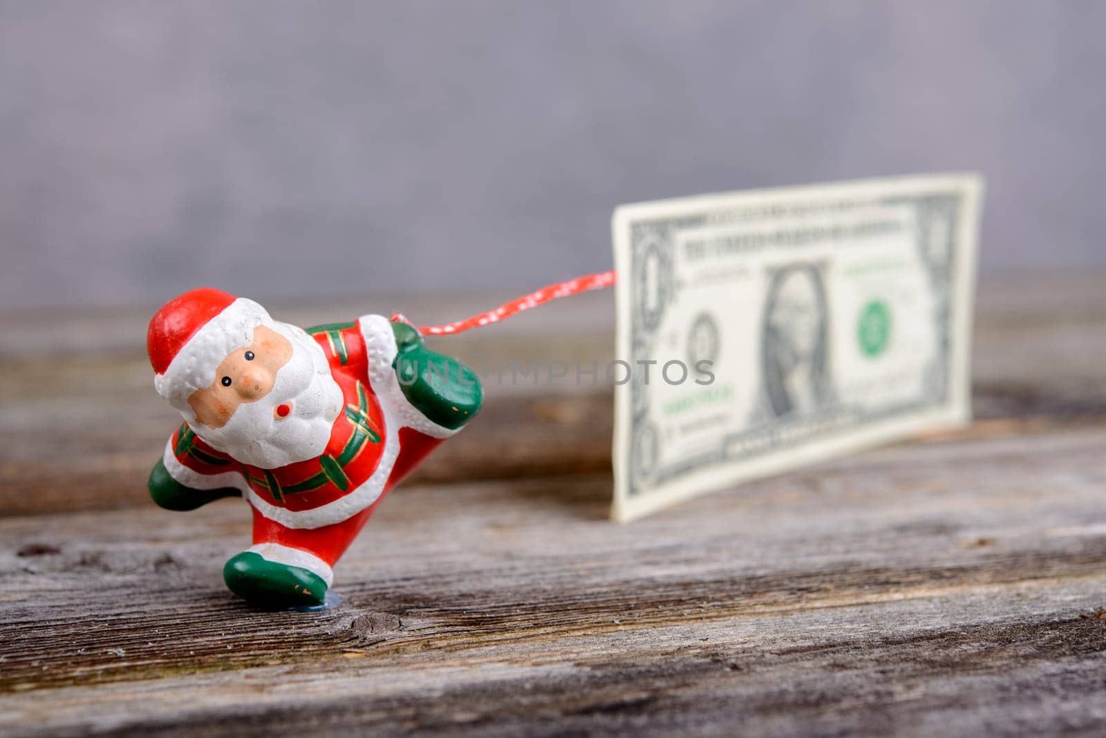 little Santa Claus pulling big euro banknote