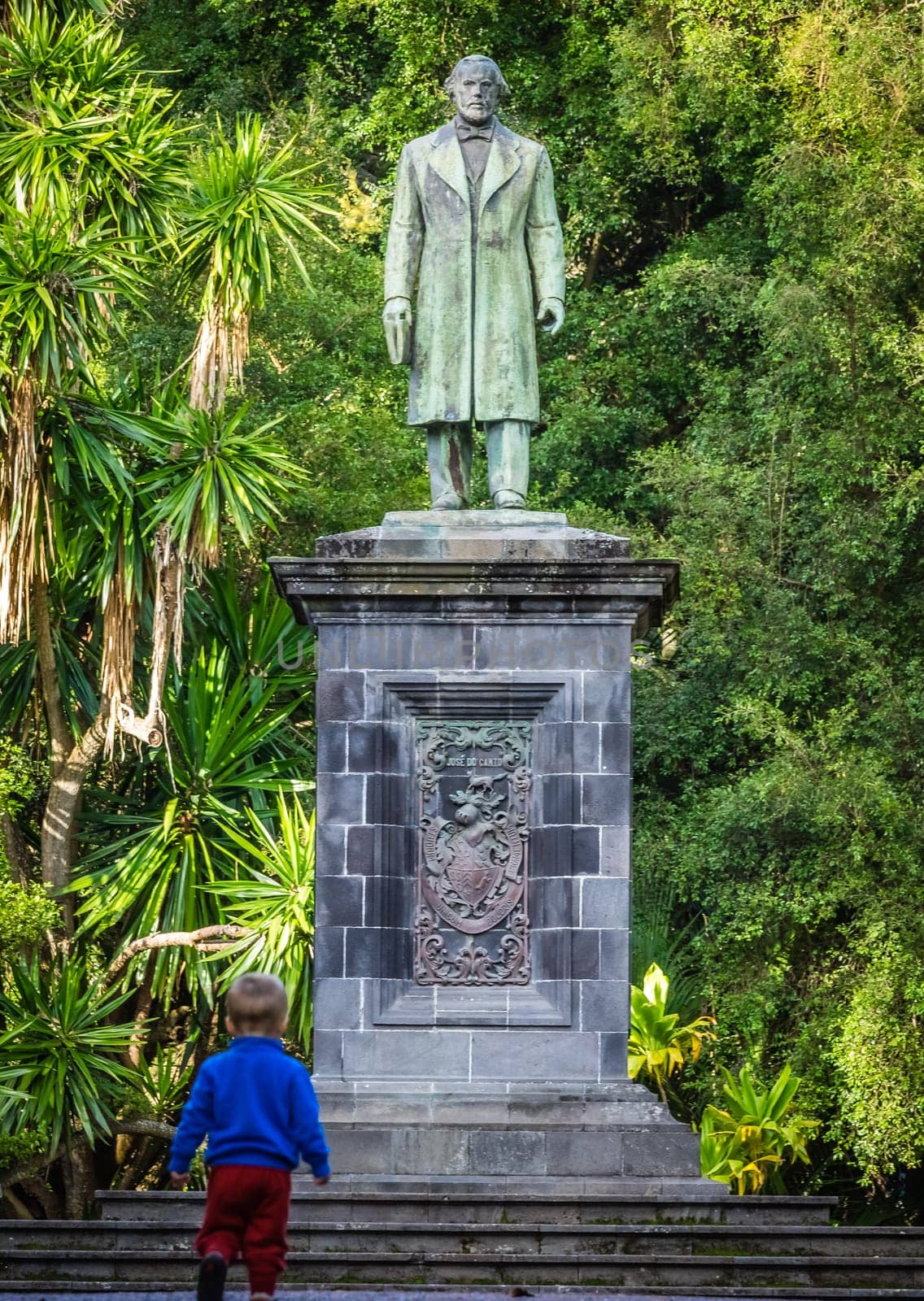 Little boy under the sculpture in the José do Canto Botanical Garden in Ponta Delgada, the capital of Sao Miguel island, Azores, Portugal