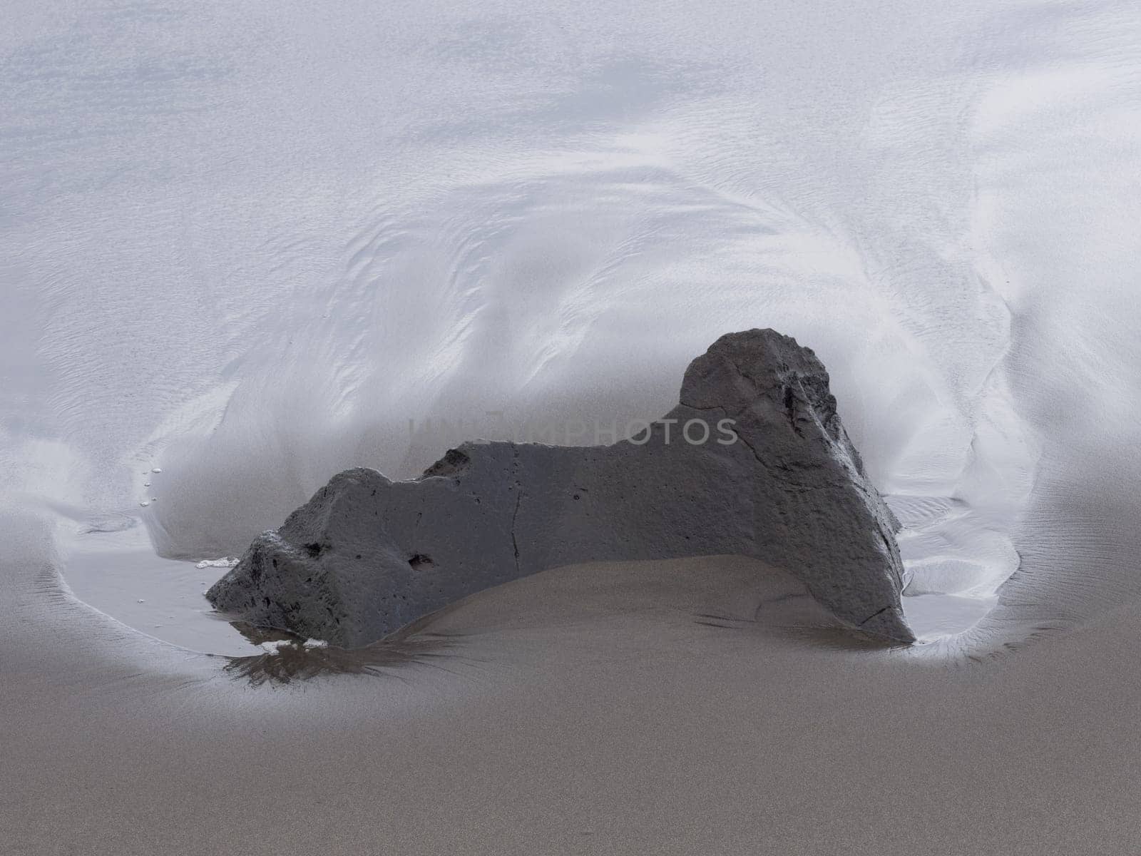 Large rock surrounded by silky blurred water on the coastline of Sao Miguel Island in the Azores