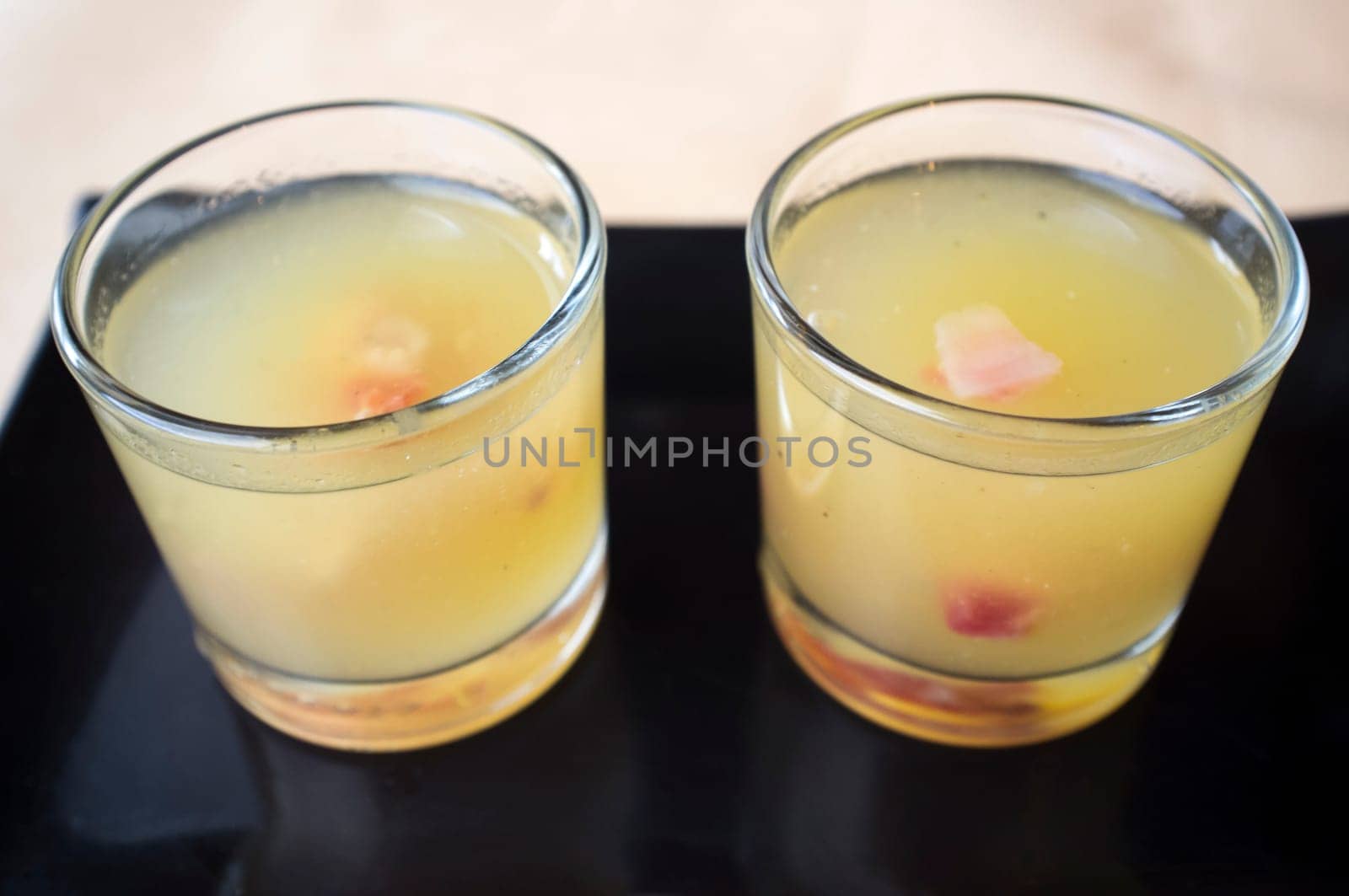 Two melon cocktails with ham over black clay tray. Selective focus