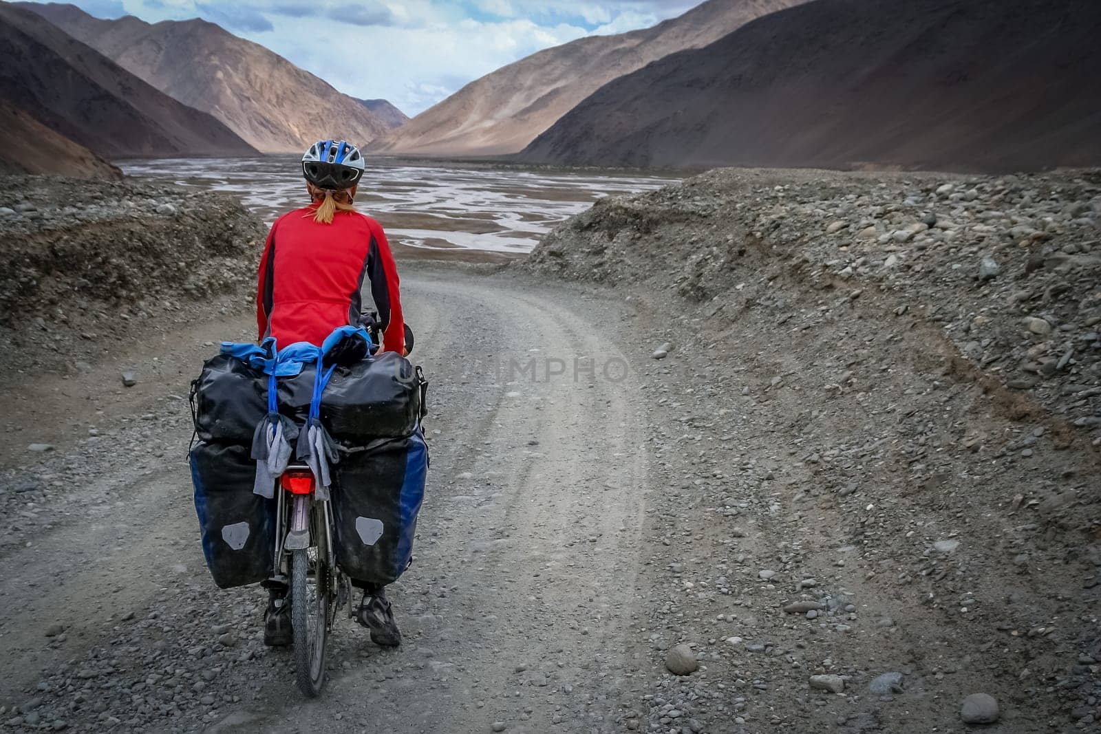Solo female cyclist cycle touring through the stunning remote landscape of Western Tibet