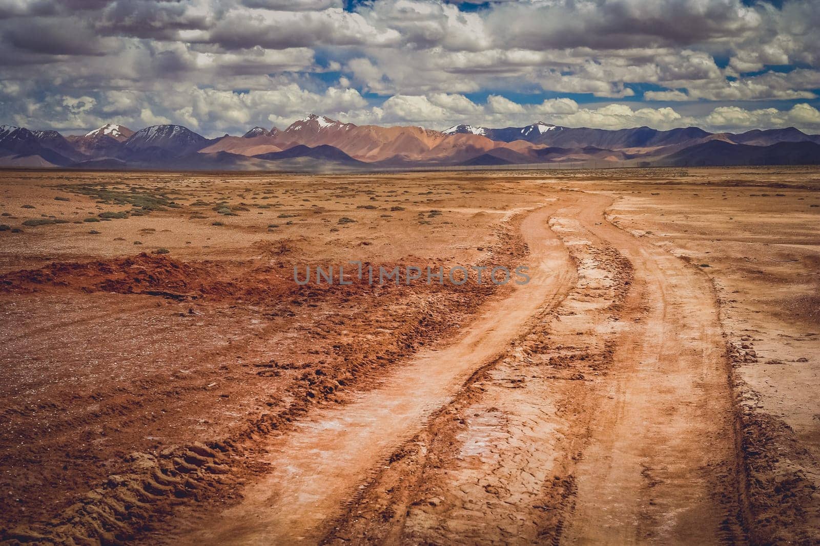 Muddy and clay mountain road through the high central Tibetan plateau, Tibet, China