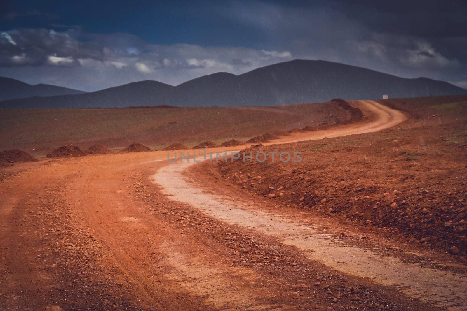 Snow falling in summer on a muddy and clay mountain road through the high central Tibetan plateau, Tibet, China