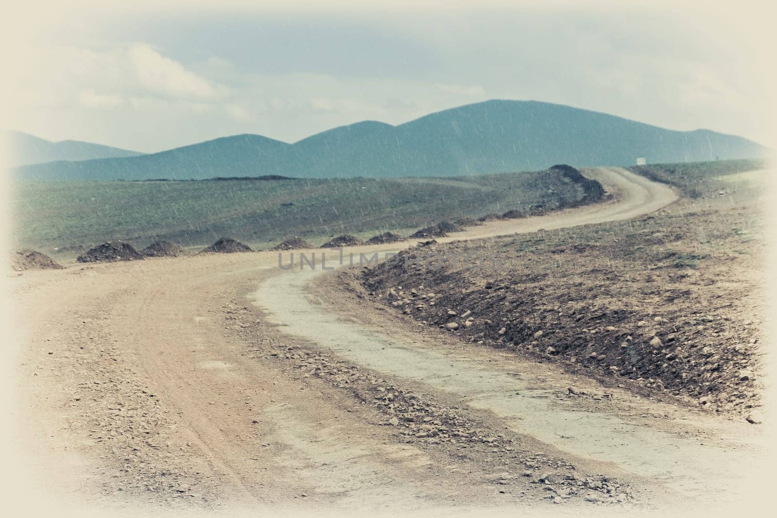 Snow falling in summer on a muddy and clay mountain road through the high central Tibetan plateau, Tibet, China