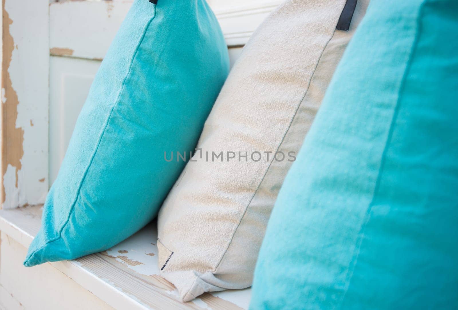 Colourful pillows on white wooden bench. Simple and clear design and colours