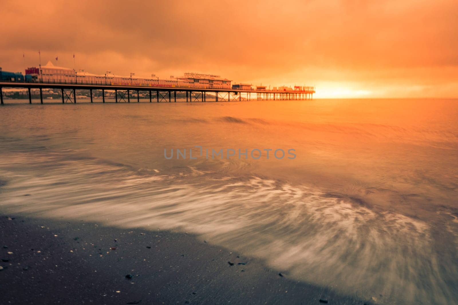 Paignton Pier on Paignton beach near Torquay in Devon during spectacular sunset