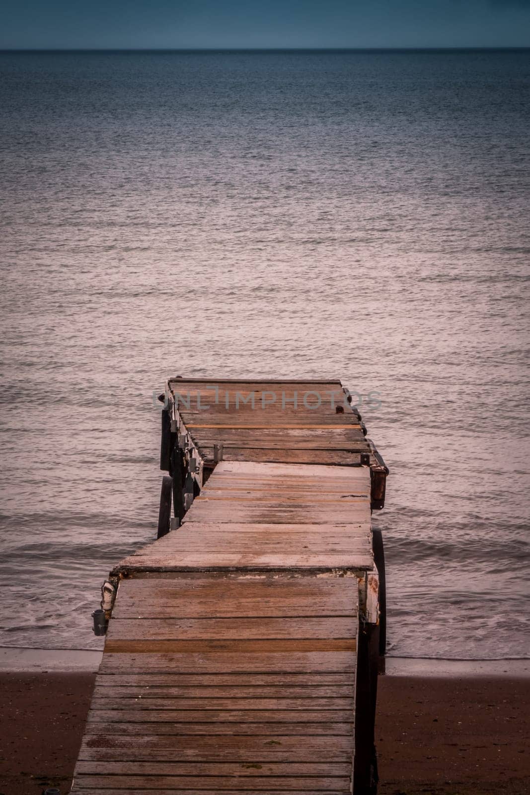Small wooden pier leading into the sea in Paignton, Torbay, Devon, UK