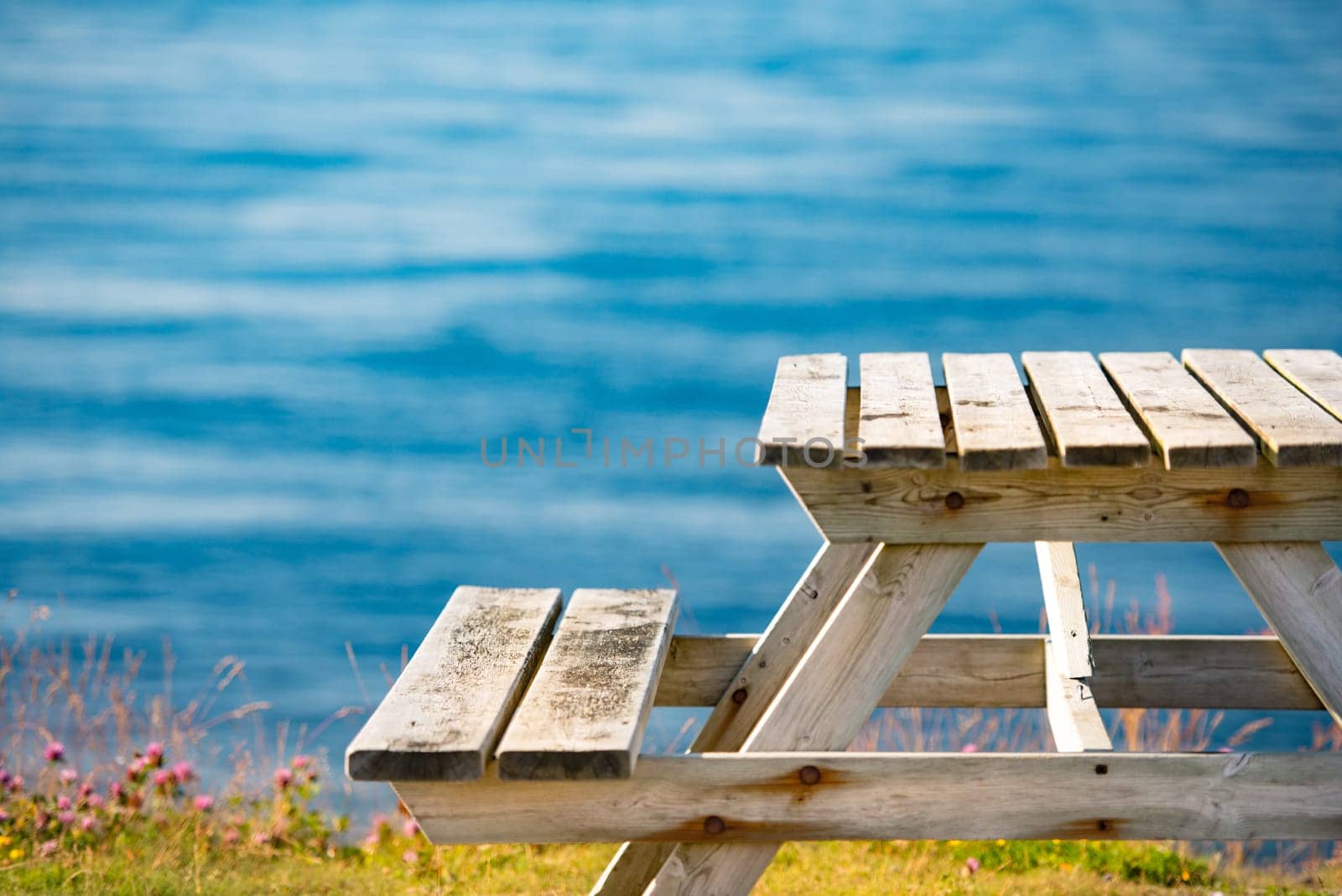 Wooden bench and table on shore in Norway, Europe. Place for relaxation and outdoor activities.