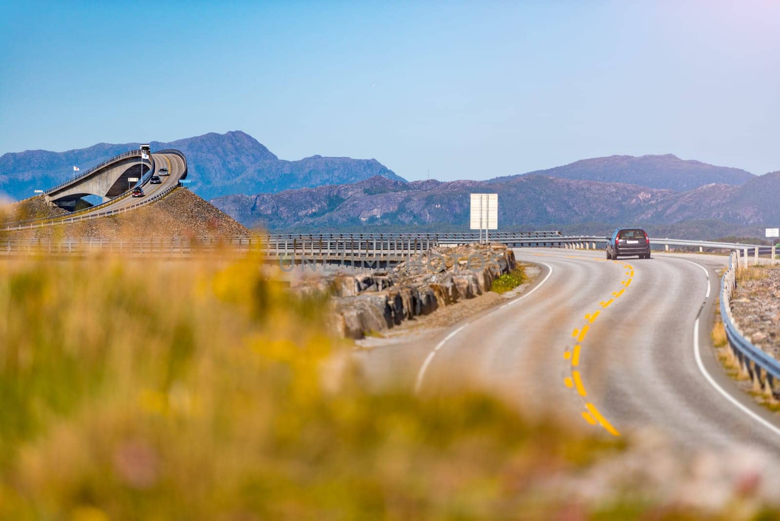 Car on Atlantic road in Norway, Europe. Auto travel through scandinavia. Blue sky in background.