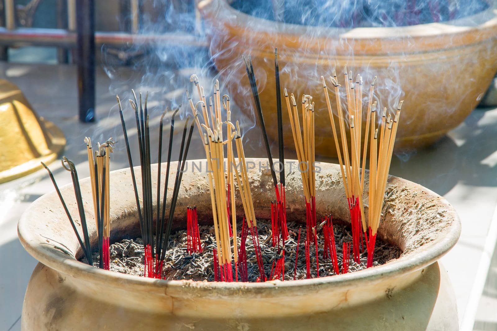 Incense burner with orange incense and black smoke.